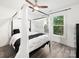 Bright bedroom features a four poster bed with canopy, ceiling fan, and a sunny window at 9712 Worley Dr, Charlotte, NC 28215