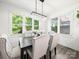 Elegant dining room features modern light fixture and large windows overlooking lush greenery at 9712 Worley Dr, Charlotte, NC 28215