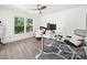 Bright office with a large window, dark wood floors, ceiling fan, monitor setup, and comfy chair at 9712 Worley Dr, Charlotte, NC 28215