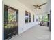 Covered porch view with a black door, ceiling fan, and multiple windows that add natural light to the area at 9712 Worley Dr, Charlotte, NC 28215