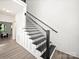 Staircase with black railings and wood flooring at 9712 Worley Dr, Charlotte, NC 28215