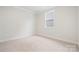 Empty bedroom featuring neutral carpet, white walls, large window and white trim at 9924 Manor Vista Trl, Kannapolis, NC 28027