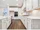 Modern kitchen boasts white cabinets, stainless steel appliances, and a farmhouse sink at 9924 Manor Vista Trl, Kannapolis, NC 28027