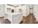 Bright kitchen features a large island, white cabinets, stainless steel appliances, and wood floors at 9924 Manor Vista Trl, Kannapolis, NC 28027