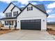 Modern farmhouse style home with a two-car garage, white siding and black trim on a sunny day at Lot 100 Coppergate Dr, Salisbury, NC 28147
