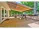 Wood deck featuring an awning, a grill, and a lawn mower, with a view of the green backyard at 1066 Iveywood Nw Pl, Concord, NC 28027