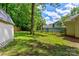 Green backyard featuring a split rail fence and mature trees, providing a private outdoor space at 1066 Iveywood Nw Pl, Concord, NC 28027