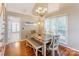 Dining room features a modern chandelier, bench seating, and a view into the living room at 1066 Iveywood Nw Pl, Concord, NC 28027