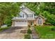 Charming two-story home with a well-manicured lawn, brick accents and a two-car garage, surrounded by lush trees at 1066 Iveywood Nw Pl, Concord, NC 28027