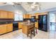 Spacious kitchen with black appliances, granite countertops, a center island, and a vaulted ceiling at 1066 Iveywood Nw Pl, Concord, NC 28027