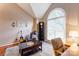 Bright living room showcasing hardwood floors, a guitar, decor, and a large window at 1066 Iveywood Nw Pl, Concord, NC 28027