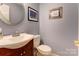 Well-lit powder room featuring a vanity with a white sink and decorative mirror at 1066 Iveywood Nw Pl, Concord, NC 28027
