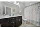 Well-lit bathroom featuring a double sink vanity with stylish fixtures and a shower with a patterned curtain at 11216 Preservation Ln, Charlotte, NC 28278