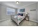 Comfortable bedroom with iron bed, a large window, decorative lamps, and stylish accents for a cozy retreat at 11216 Preservation Ln, Charlotte, NC 28278