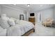 Spacious bedroom with a wooden bed, TV, large mirror, and a decorative chair for a comfortable retreat at 11216 Preservation Ln, Charlotte, NC 28278