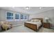 Inviting bedroom with a wooden bed, a patterned accent chair, and ample natural light from three large windows at 11216 Preservation Ln, Charlotte, NC 28278