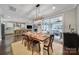 Inviting dining area with wood table and chairs, opening to a bright patio and modern kitchen with stainless steel appliances at 11216 Preservation Ln, Charlotte, NC 28278