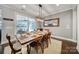 Elegant dining room features a farmhouse table with seating for six, stylish light fixture, and sliding glass doors to patio at 11216 Preservation Ln, Charlotte, NC 28278