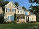 Charming two-story home with a covered front porch, manicured lawn, and inviting curb appeal at 11216 Preservation Ln, Charlotte, NC 28278