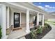 Inviting front porch features classic white columns, fresh flowers, and a cozy rocking chair, creating a welcoming entrance at 11216 Preservation Ln, Charlotte, NC 28278