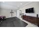 Bright home gym with a wall-mounted TV, rubber mat flooring, and a weight rack, creating a functional fitness area at 11216 Preservation Ln, Charlotte, NC 28278
