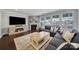 Living room with large sofa, fireplace, hardwood floors, and large windows at 11216 Preservation Ln, Charlotte, NC 28278