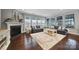 Bright living room featuring a fireplace, neutral decor, hardwood flooring, and ample natural light at 11216 Preservation Ln, Charlotte, NC 28278