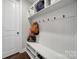Well-organized mudroom with white beadboard paneling, built-in shelving, coat hooks, and storage bench at 11216 Preservation Ln, Charlotte, NC 28278