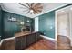 Bright home office with geometric wallpaper, wooden shelves, a large wooden desk, hardwood floors and transom-topped doorway at 11216 Preservation Ln, Charlotte, NC 28278