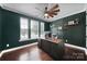 Stylish home office featuring dark green walls, designer wallpaper, a large wooden desk, and hardwood flooring at 11216 Preservation Ln, Charlotte, NC 28278