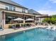 Lush backyard featuring a pool, tanning ledges, patios, and outdoor cooking spaces at 1152 Grand Oak Dr, Waxhaw, NC 28173