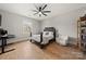 Bright bedroom featuring a wood floor, large window, ceiling fan and a comfortable seating area at 1152 Grand Oak Dr, Waxhaw, NC 28173