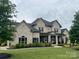 Stately two-story home boasts a well-manicured lawn and refined landscaping with a covered entryway and classic design at 1152 Grand Oak Dr, Waxhaw, NC 28173