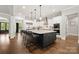 Modern kitchen boasts a large island, stainless steel appliances, and sleek white and dark cabinetry at 1152 Grand Oak Dr, Waxhaw, NC 28173
