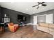 Relaxing living room featuring dark accent wall, comfortable seating, and a modern entertainment center at 1152 Grand Oak Dr, Waxhaw, NC 28173