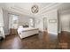 Hardwood floors, tray ceiling, and a doorway lead to the primary bath in this bedroom at 1152 Grand Oak Dr, Waxhaw, NC 28173
