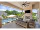Covered patio with a stone fireplace, comfortable seating, and a view of the swimming pool at 1152 Grand Oak Dr, Waxhaw, NC 28173