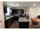 Bright kitchen with black cabinets, gray backsplash, granite counters, and stainless steel refrigerator at 116 Crownpiece St, Troutman, NC 28166