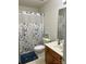 Clean bathroom featuring floral shower curtain and wooden vanity at 12238 Paperbark Cir, Charlotte, NC 28277
