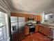 Well-equipped kitchen featuring wood cabinetry, granite countertops, and stainless steel appliances at 12238 Paperbark Cir, Charlotte, NC 28277