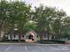 Community pool house entrance with parking, manicured landscaping, and mature trees at 12238 Paperbark Cir, Charlotte, NC 28277