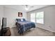 Bright bedroom with a large window, ceiling fan and plaid bedding, offering a comfortable space at 12517 Pine Terrace Ct, Charlotte, NC 28273