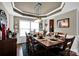 Elegant dining room with tray ceiling, large windows, and hardwood floors at 12517 Pine Terrace Ct, Charlotte, NC 28273