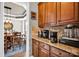 Butler's pantry with granite countertops and rich wood cabinets, leads to formal dining at 12517 Pine Terrace Ct, Charlotte, NC 28273