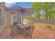 Outdoor patio area features a stone tile floor, grill and seating under a large umbrella at 12517 Pine Terrace Ct, Charlotte, NC 28273