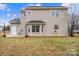 Back exterior view of a beige siding home with a bay window, door and small patio area at 130 Valley Glen Dr, Troutman, NC 28166