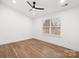 Bedroom featuring wood flooring, ceiling fan, and a window with ample natural light at 130 Valley Glen Dr, Troutman, NC 28166