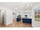 Open-concept kitchen with an island featuring quartz countertops and an elegant chandelier at 130 Valley Glen Dr, Troutman, NC 28166