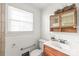Bathroom with marble vanity, decorative mirror, and window for natural light at 1320 Hartford Ave, Charlotte, NC 28209