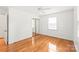 Bright bedroom with hardwood floors, a ceiling fan, and a mirrored closet, offering a clean and inviting space at 1320 Hartford Ave, Charlotte, NC 28209